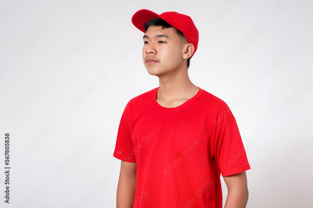 Fototapeta premium Courier Delivery worker shipping concept. Portrait of Smiling young asian Delivery man in red uniform isolated on white background