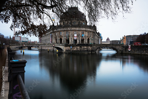 Das Berliner Bodemuseum mit Spiegelung im Wasser und einem Baum im Vordergrund  photo