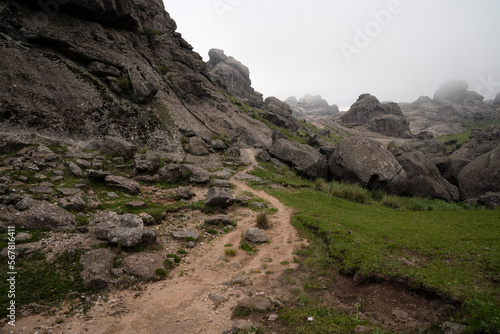 View of the hiking path across the rocky hill in a foggy early morning. 