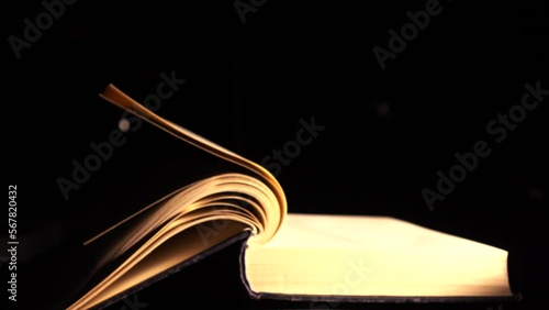 The pages of the book turn over by themselves. Slow-motion video of turning the page of an old book