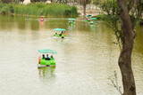People get on boat at Huacachina village lake with palm trees and sand hills. Selective focus. 