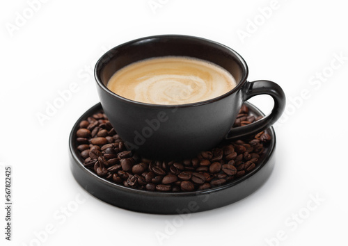 Large porcelain cup of hot creamy black coffee and fresh raw beans on saucer on white background