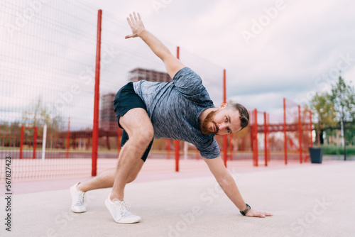 Flexible man exercising at stadium