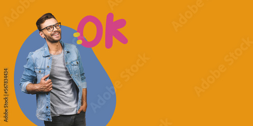 Casually handsome. Confident young handsome man in jeans shirt smiling while standing against yellow background.