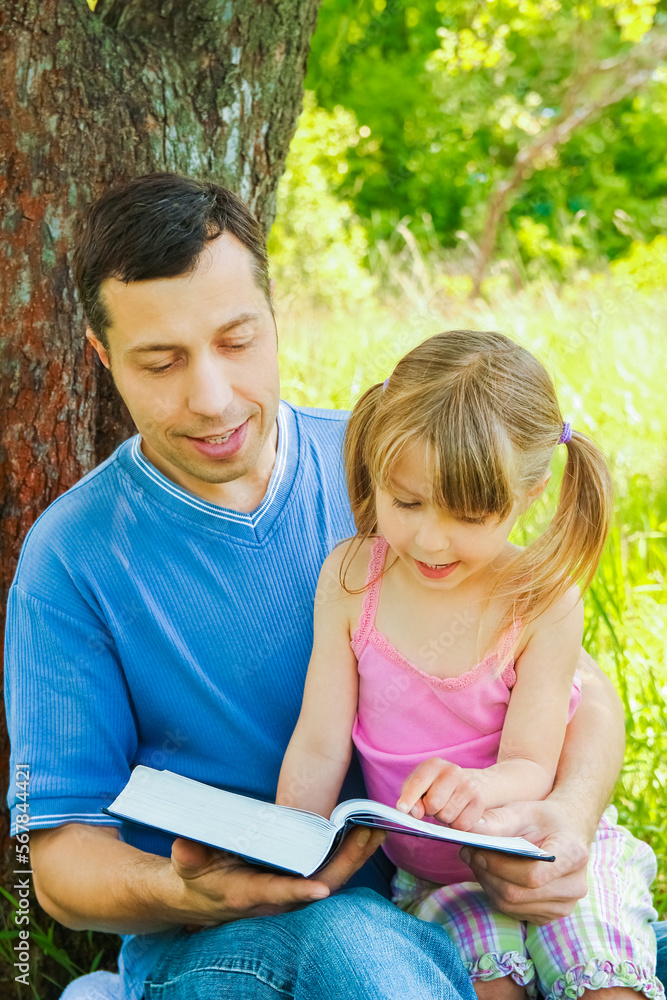 young father with a small daughter reading the Bible young father with a small daughter reading the Bible