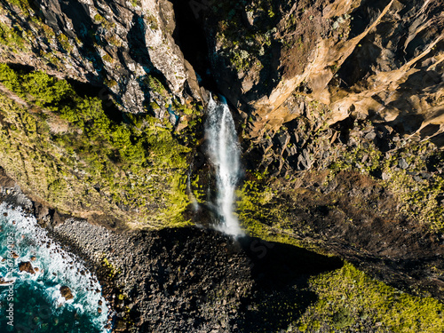 Ponta do Poiso waterfall on the north coast of the Madeira, Portugal, Seixal, shot from a drone, a majestic waterfall in the middle of a diverse landscape photo