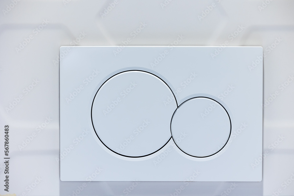 Close-up of white toilet bowl flush buttons. Toilet finished with white tiles
