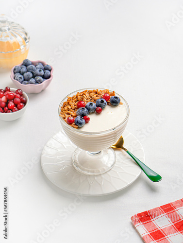 Creamy dessert with berries on white table