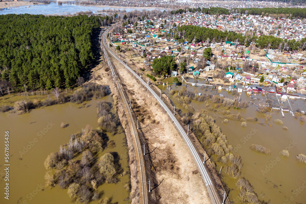 Railway tracks passing through the flooded area and rural areas, aerial view