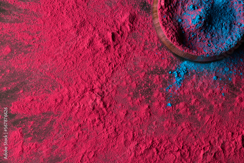 Close up of multi coloured powder and bowl with copy space on black background