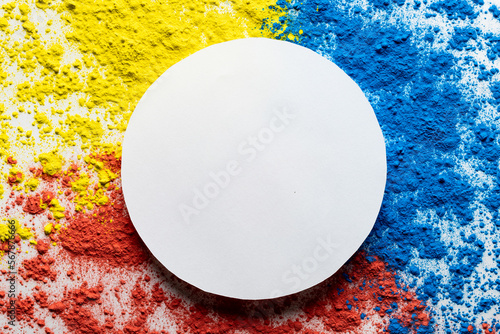 Close up of multi coloured powder and white circle with copy space on white background