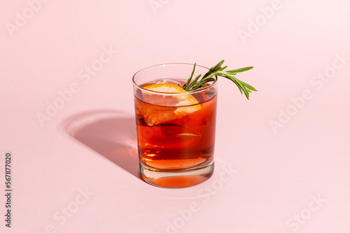 Glass with drink and fruits over pale pink background