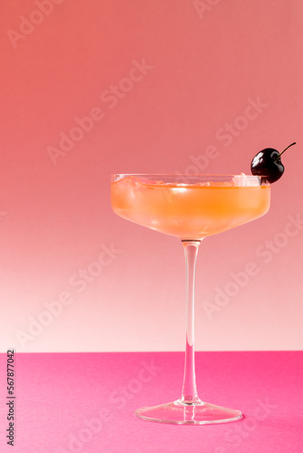 Vertical image of glass with drink and fruits over pink background