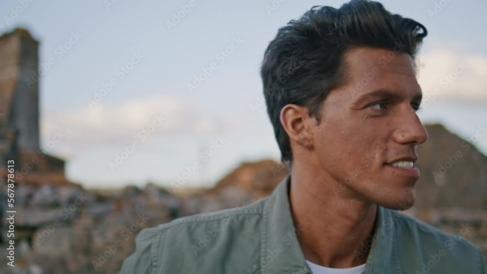 Handsome guy smiling camera at summer landscape portrait. Man posing at village Handsome guy smiling camera at summer landscape portrait. Man posing at village