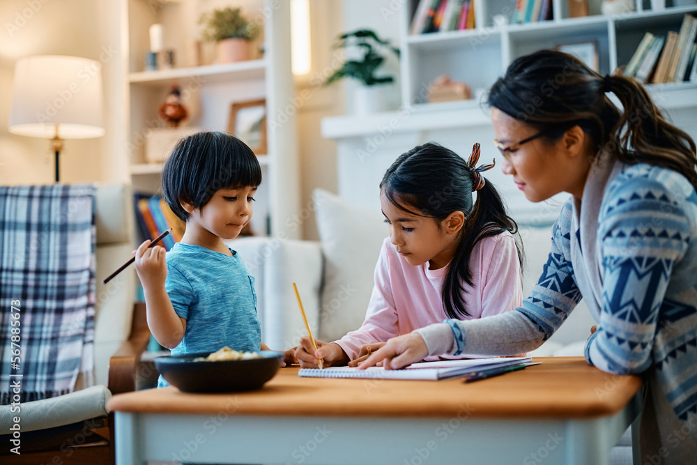 Small Asian kids and their mother enjoy in coloring on paper at home. Small Asian kids and their mother enjoy in coloring on paper at home.