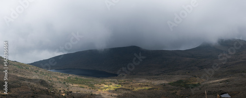Rocky paramo landscape with fog and lake in a cloudy day