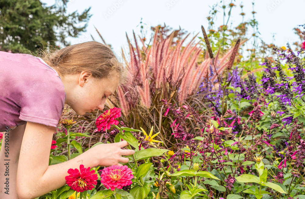 Girl smells flowers in garden Girl smells flowers in garden
