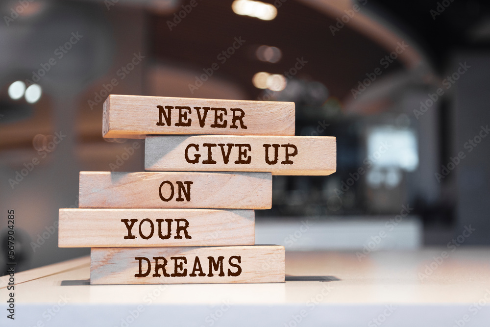 Wooden blocks with words 'Never give up on your dreams'.