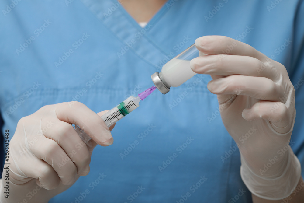 Doctor filling syringe with hepatitis vaccine from glass vial, closeup Doctor filling syringe with hepatitis vaccine from glass vial, closeup