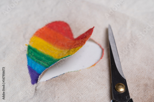 corazón pintado a mano con colores de bandera del orgullo gay, recortado y tijeras a un lado photo