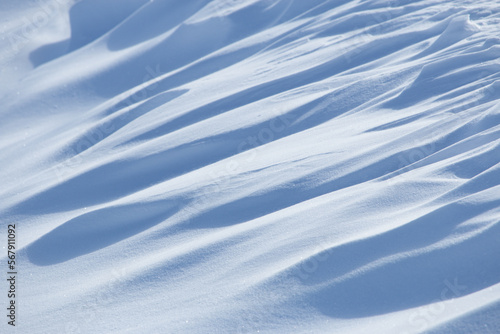 Abstract shadow and light patterns in white winter snow natural background