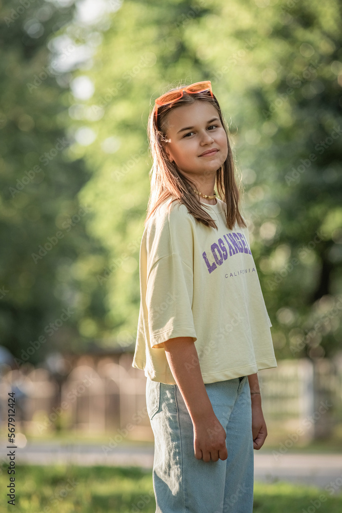 Portrait of a young beautiful girl in jeans and a T-shirt in a summer park. Portrait of a young beautiful girl in jeans and a T-shirt in a summer park.