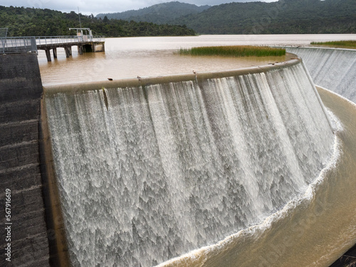 The Lower Nihotupu Reservoir shows water cascading and overflowing the side walls due to record breaking heavy rainfall in New Zealand.Waitakere