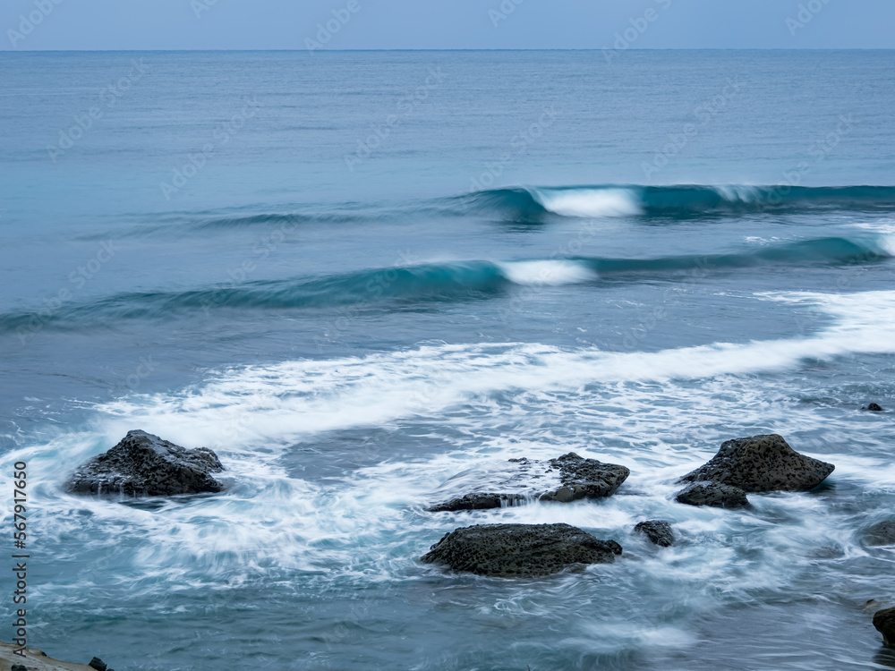 Sea waves impact rock on the beach