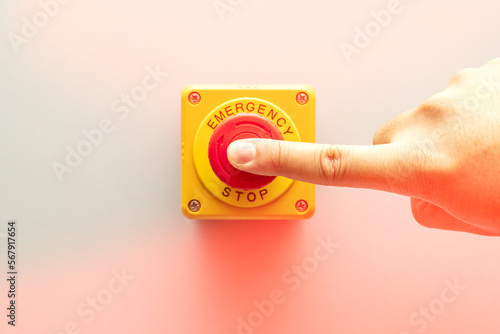 Stop Button and the Hand of Worker About to Press it. emergency stop button. Big Red emergency button or stop button for manual pressing.