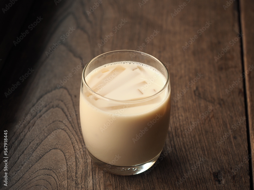 glass of soy milk on wooden table glass of soy milk on wooden table