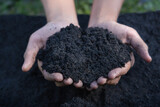 Hands holding abundance soil for agriculture or preparing to plant  Testing soil samples on hands with soil ground background. Soil quality and farming concept. Selective focus on black soil in front