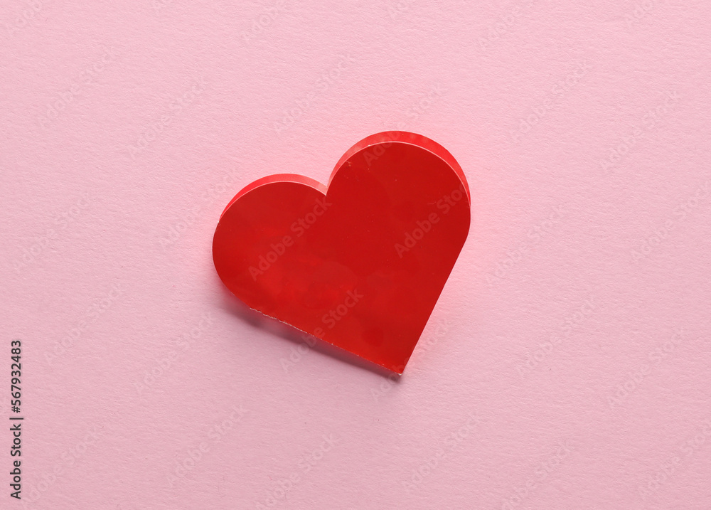 Red paper heart shaped valentine on pink background