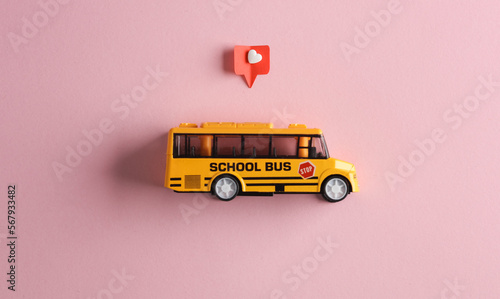 Toy school bus with Social media like on pink background. Creative minimal layout