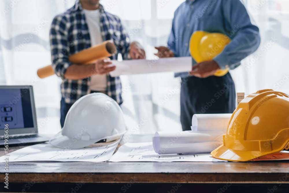 Engineers consulting team close up to design building blueprints paper for clients with building models to work at office. Engineers consulting team close up to design building blueprints paper for clients with building models to work at office.