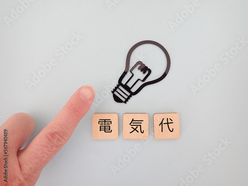 電球と電気代の単語、上を指差している