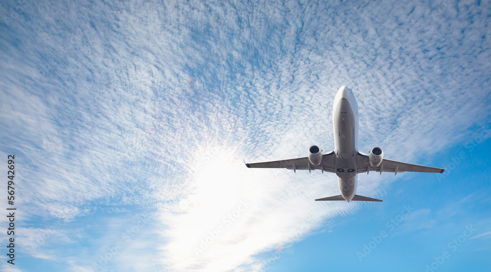 Obraz premium White passenger airplane flying in the sky amazing clouds in the background - Travel by air transport