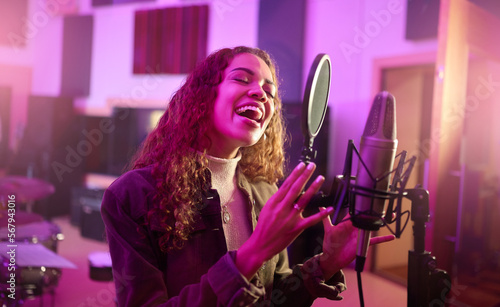Musician, singing or woman on neon studio microphone, music equipment or practice in night theatre recording. Singer, person or artist on production, voice media or sound performance in light theater
