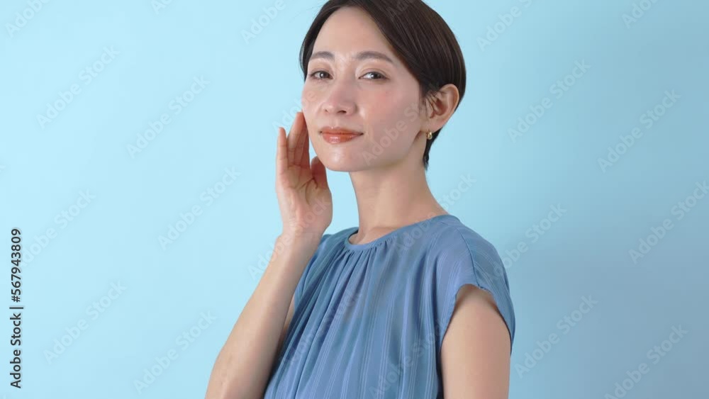 カメラ目線で笑顔で肌に触れる日本人女性