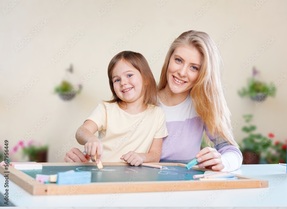 Happy mom helping child to study at home Happy mom helping child to study at home