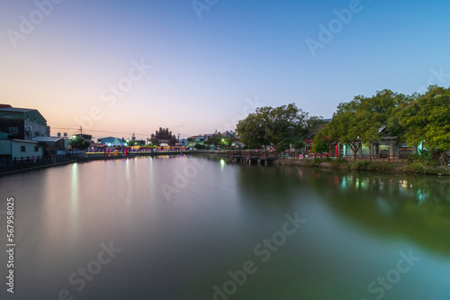 The temple, the blue lake and the green trees make a beautiful rural landscape. Dusk view of the countryside. Shanhua District, Tainan City, Taiwan