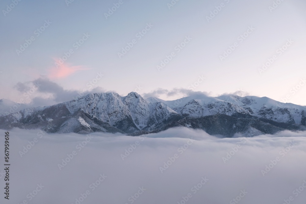 Winter scenery of panorama of Tatras Mountains with characteristic Giewont peak with cross, and clouds under them from Gubalowka hill in Zakopane, Podhale, Poland
