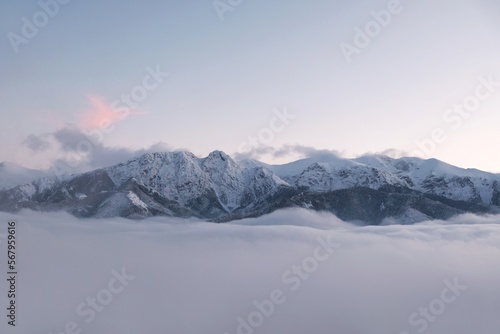 Winter scenery of panorama of Tatras Mountains with characteristic Giewont peak with cross, and clouds under them from Gubalowka hill in Zakopane, Podhale, Poland © Iwona