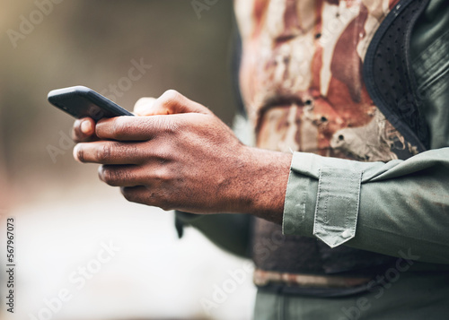 фотографія Phone, camouflage and solider at war on social media or browsing internet, app or website at military or army