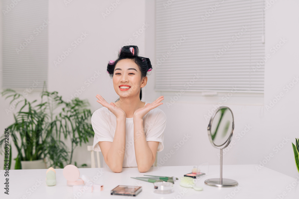 Close up smiling young woman wearing white t-shirt doing facial massage Close up smiling young woman wearing white t-shirt doing facial massage