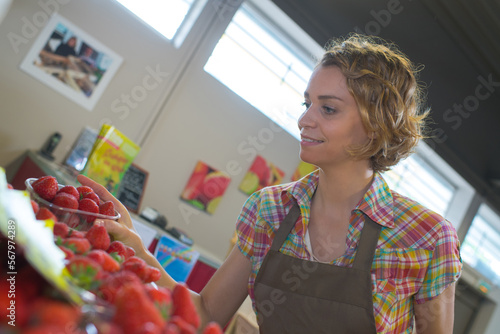 Fotografija fruit market saleswoman selecting fresh fruit