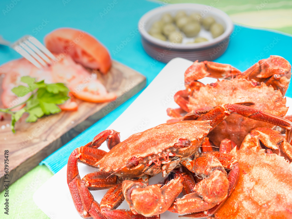 Cooked velvet crabs served with tomatoes and olive Cooked velvet crabs served with tomatoes and olive