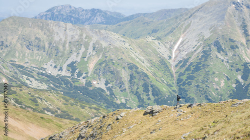 Male hiker with backpack walking down the ridge amongst big mountains , EU, Slovakia photo