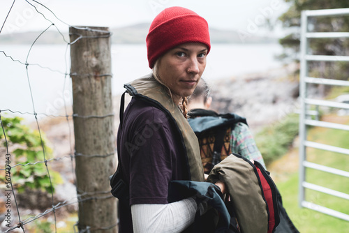 women prepare for boat trip walking through gate in remote Scotland photo