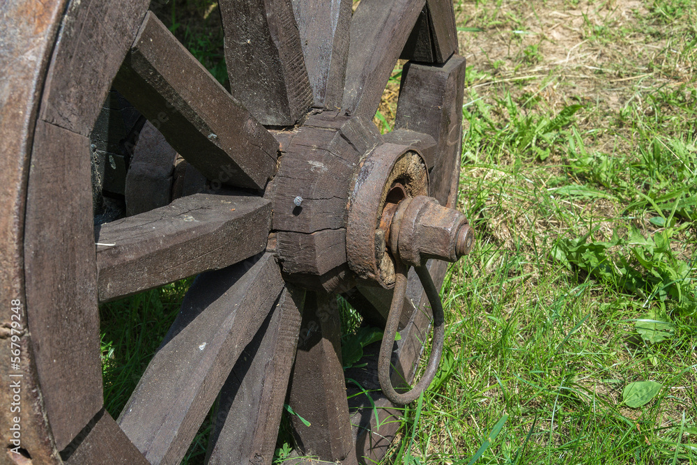Mounting an old wooden wheel on a rural cart, close - up Mounting an old wooden wheel on a rural cart, close - up