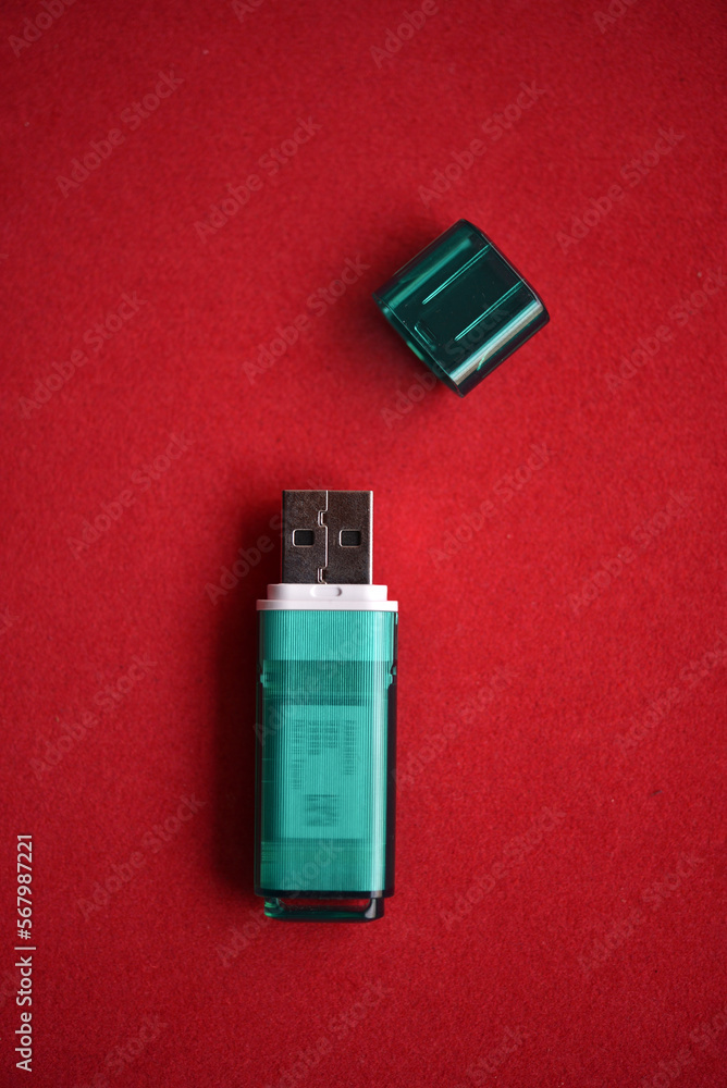 USB flash drive close-up on a red background. One USB flash drive with a lid. USB flash drive close-up on a red background. One USB flash drive with a lid.